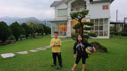 two children standing in a yard in front of a house at Star House in Tianfu