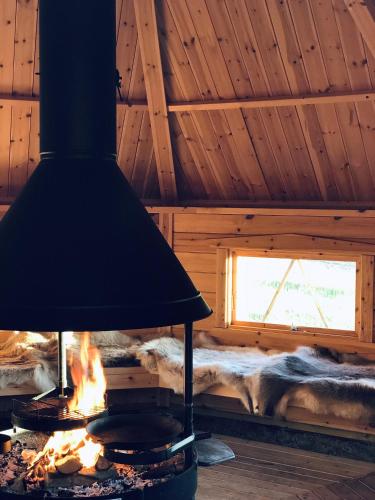 a fireplace in a log cabin with a window at Högbo Hotell Skommarsgården in Sandviken