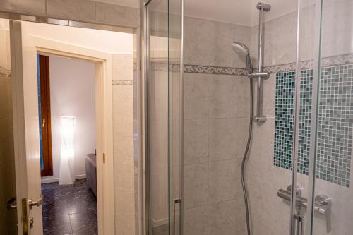 La salle de bains est pourvue d'une douche avec une porte en verre. dans l'établissement The Heart of San Marco - WiFi, à Venise