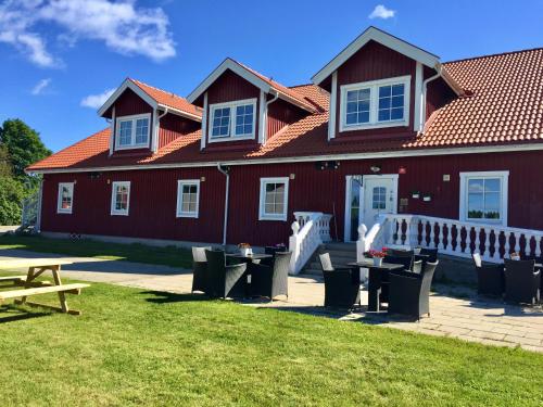 a red building with picnic tables in front of it at Högbo Hotell Skommarsgården in Sandviken