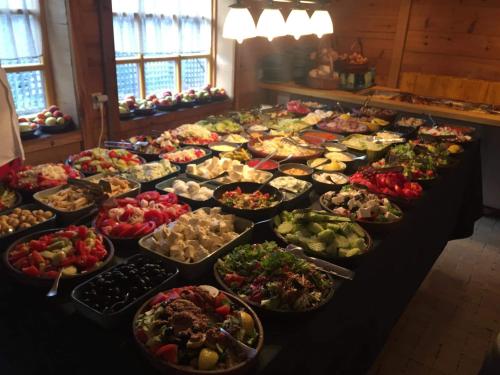 una mesa llena de muchos tipos de alimentos diferentes en Mecavnik Resort, en Mokra Gora