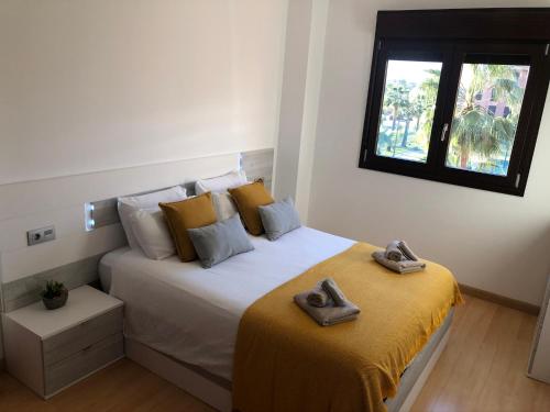 a bedroom with a bed with two slippers on it at PUSHE Playa Granada Beach&Golf 1 in Motril