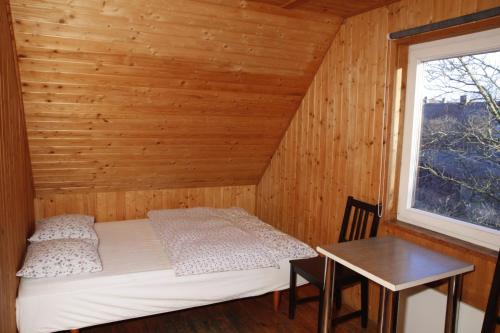 Bett in einem Zimmer mit einem Tisch und einem Fenster in der Unterkunft The Jolly Man in Vilnius