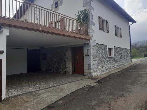a white building with a balcony on top of it at Aizalegia in Igantzi
