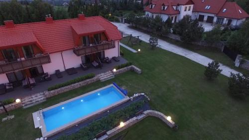 a house with a swimming pool in a yard at Apartamenty Pod Łysicą & SPA - przy stoku, basen, jacuzzi, sauna in Krajno Pierwsze