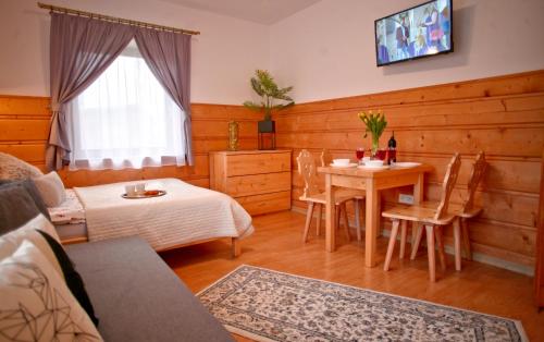 a living room with a table and a dining room at Willa Przy Skoczni in Zakopane