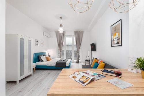 uma sala de estar com uma cama e uma mesa em Palm Aparts Warsaw em Varósvia