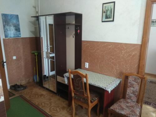 een kamer met een tafel en stoelen en een kast bij Двохповерховий будинок з двома апартаментами in Truskavets