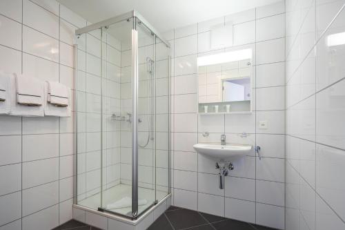 a bathroom with a glass shower and a sink at Marina Walensee Hotel in Unterterzen