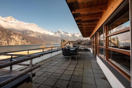 a balcony with chairs and a view of the mountains at Marina Walensee Hotel in Unterterzen