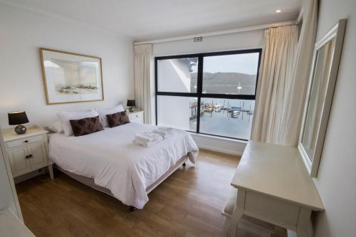 a bedroom with a bed and a large window at Laguna Grove 48 in Knysna
