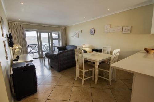 a kitchen and living room with a table and a couch at Laguna Grove 48 in Knysna
