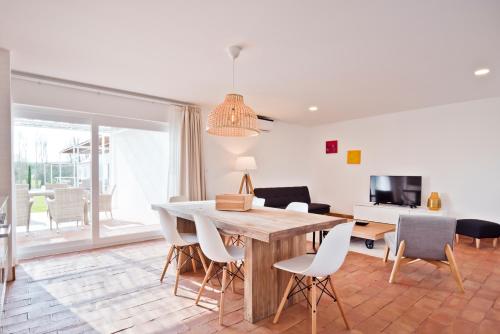 a living room with a wooden table and chairs at Herdade do Barrocal de Baixo in Montemor-o-Novo