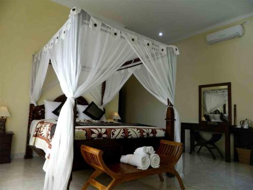 En eller flere senge i et værelse på Bali Bhuana Beach Cottages