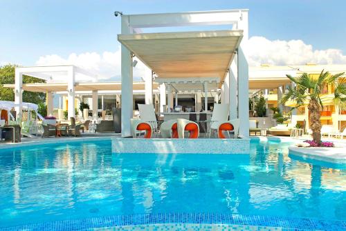 a swimming pool with a table and chairs in a building at Litohoro Olympus Resort Villas & Spa in Plaka Litochorou