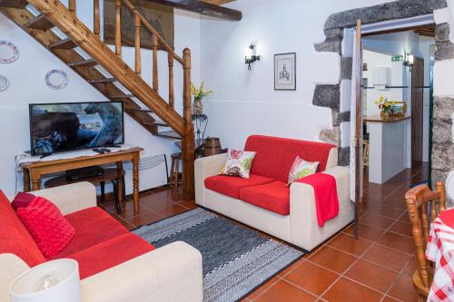 a living room with two couches and a tv at Casa da Agua Quente - AL in Furnas