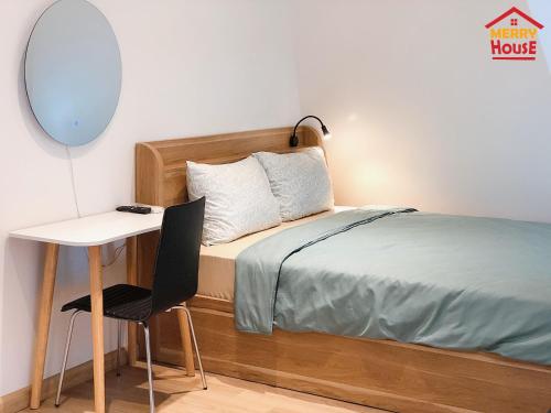 a small bedroom with a bed and a desk at Merry House Imperia in Hai Phong