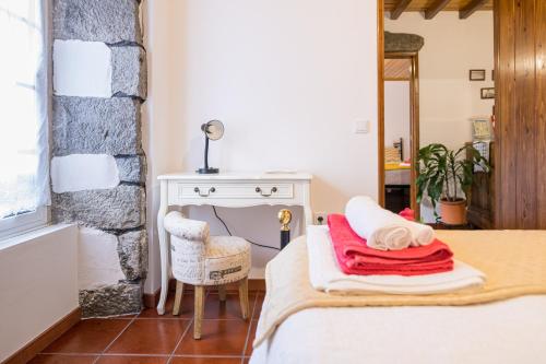 a bedroom with a bed and a desk and a chair at Casa da Agua Quente - AL in Furnas