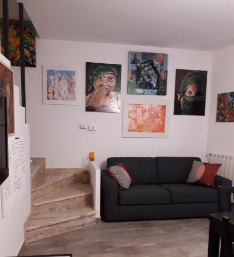 a living room with a couch and pictures on the wall at Casa degli Artisti San Lorenzo in Mezzojuso