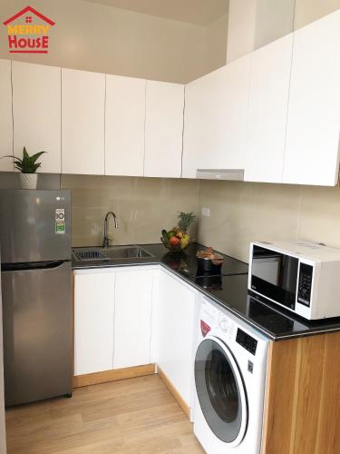 a kitchen with a washing machine and a microwave at Merry House Imperia in Hai Phong