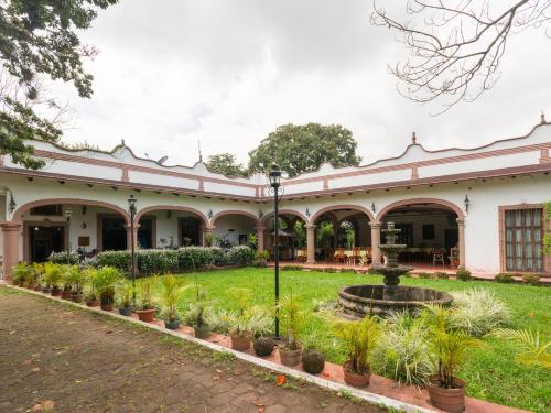 un edificio antiguo con una fuente en el patio en Rancho Hotel El Carmen, en Tlapacoyan