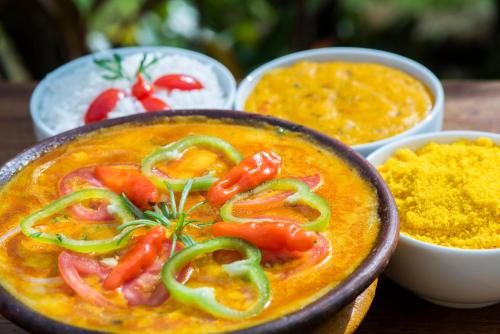 a bowl of food with peppers and other ingredients at Pousada Tropicarim in Itacimirim