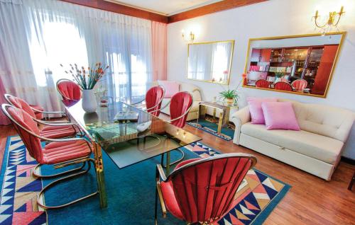 ein Wohnzimmer mit einem Glastisch und roten Stühlen in der Unterkunft Apartments Croatia in Rijeka