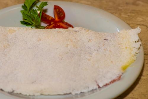 a piece of cake on a plate on a table at Pousada Tropicarim in Itacimirim