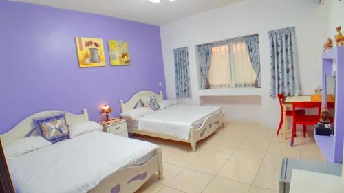 a bedroom with two beds and a desk in it at Loyofun in Donggang
