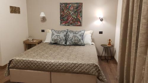 a bedroom with a bed and a painting on the wall at B&B al civico16 in Guspini