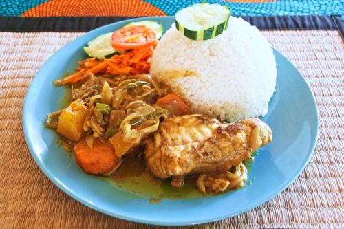 a blue plate of food with rice and seafood at Tamba Kuruba Eco-lodge in Folonko