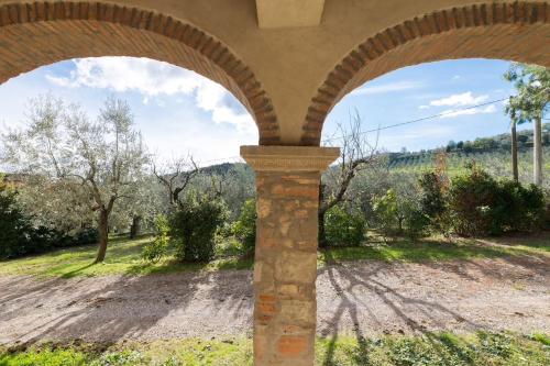an archway with a view of a field and trees at Agriturismo Fattoria Celle in Figline Valdarno