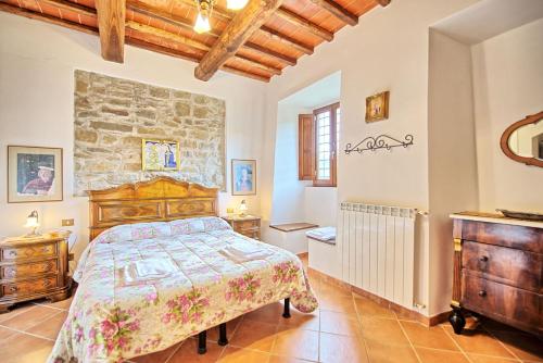 a bedroom with a bed and a stone wall at Agriturismo Fattoria Celle in Figline Valdarno
