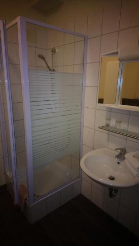 a bathroom with a glass shower and a sink at Hotel Schillerquartier in Kassel