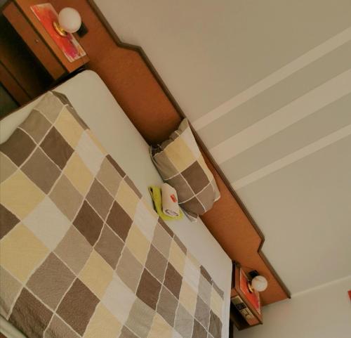 a close up of a bed with a checkered pillow at Landhotel Heidkrug in Munster im Heidekreis
