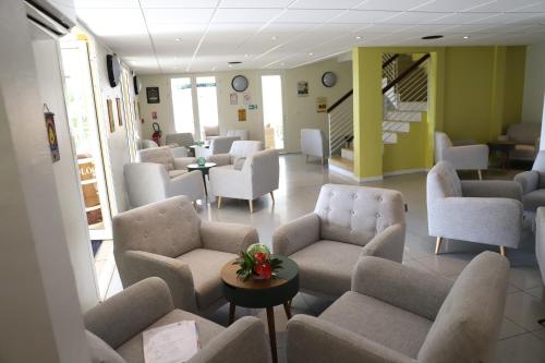 a waiting room with couches and chairs and tables at Hôtel Saint-Georges in Saint-Claude