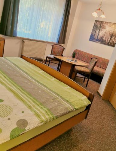 a bedroom with a bed and a table and chairs at Landhotel Heidkrug in Munster im Heidekreis