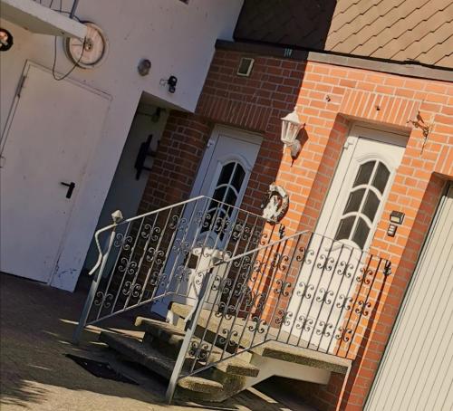 a building with a staircase in front of a door at Landhotel Heidkrug in Munster im Heidekreis
