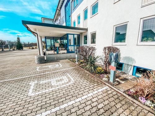 a building with a parking lot in front of it at Hotel Schwertfirm in Karlsfeld