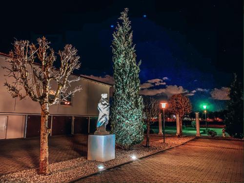 a christmas tree and a statue in front of a building at Hotel Schwertfirm in Karlsfeld