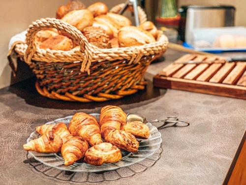 a plate of croissants and a basket of bread at Hotel Schwertfirm in Karlsfeld