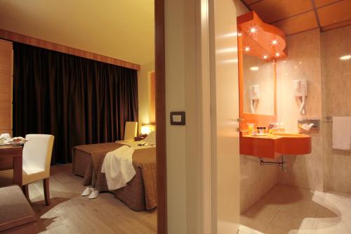 ピサにあるホテル ガリレイのベッドとシンク付きのホテルルーム