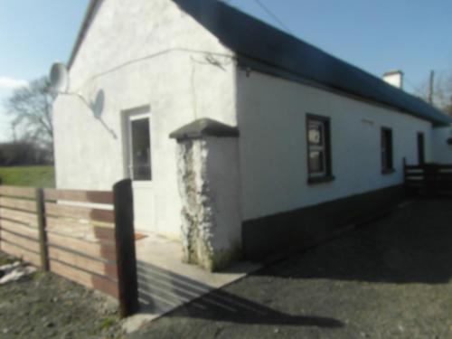 a small white building with a fence next to it at Country Studio in Portarlington