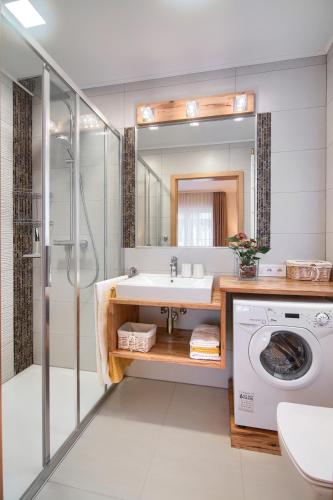 a bathroom with a sink and a washing machine at Koral in Mielno