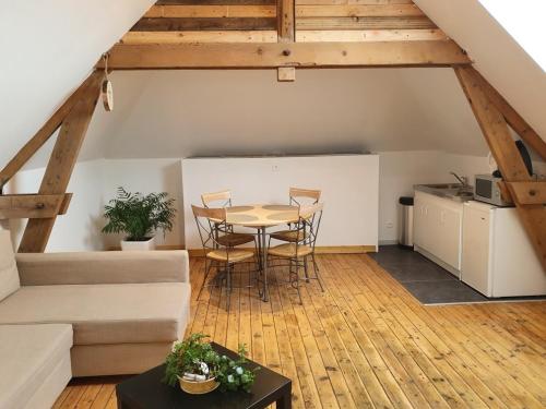 a living room with a table and a couch at Le petit manoir d'Hebuterne in Hébuterne