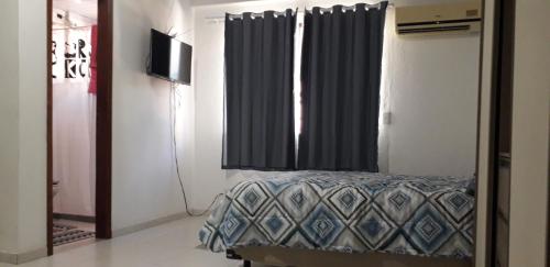 a bedroom with a bed and a window with curtains at Fort in Angra dos Reis