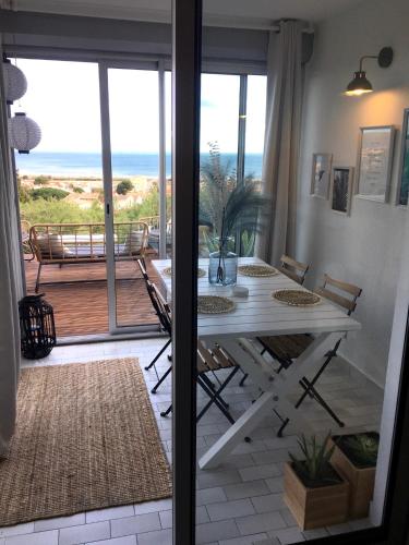 une salle à manger avec une table et une vue sur l'océan dans l'établissement Saint-Pierre-la-Mer, à Fleury