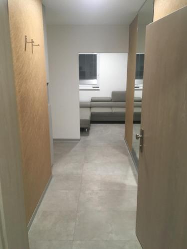 an empty hallway with a couch in a room at Apartment Sun Lakes pri Aquaparku in Senec