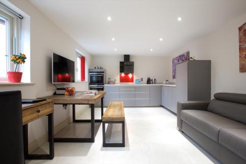 a kitchen and living room with a couch and a table at Railway Apartments in Nailsworth