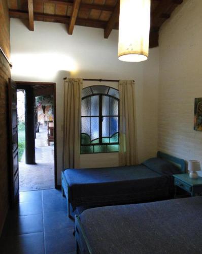 a bedroom with two beds and a window at Posada Argimon in San Marcos Sierras